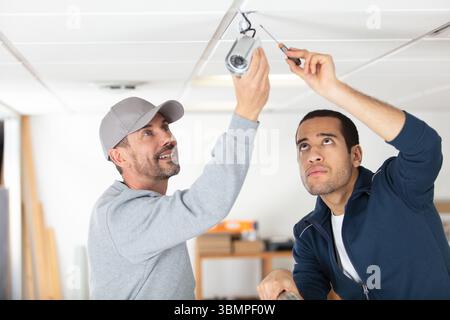 technicians installing security camera system at home Stock Photo