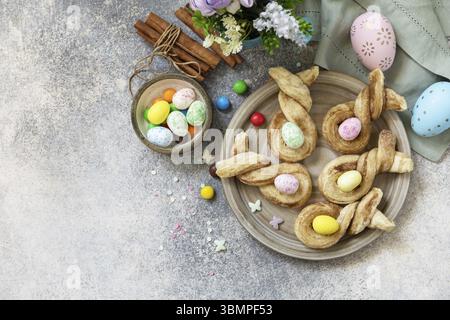 Easter rabbit-shaped buns puff pastry with cinnamon on a stone tabletop. Easter bake idea. View from above. Copy space Stock Photo