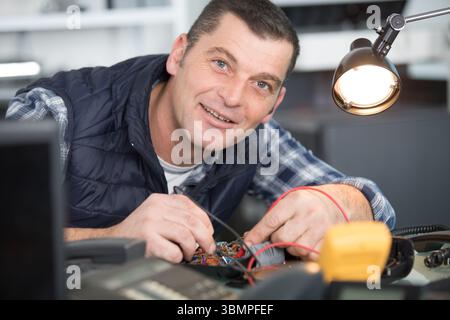 smiling handsome electrician checking electrical system Stock Photo