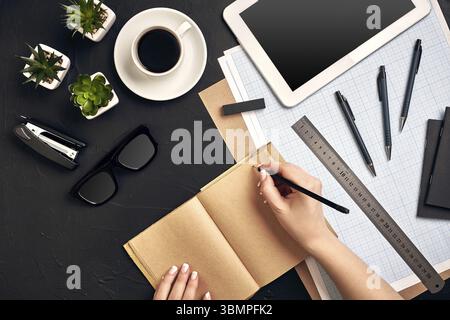 Concept architects. Architects workplace, architectural project, blueprints, ruler. Engineer holds a pen and writes in a notebook. Equipment architect Stock Photo
