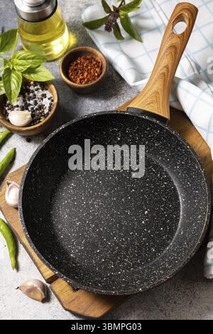 Empty skillet, vegetables, spices and herbs on gray stone background. Food cooking background with Frying pan Stock Photo