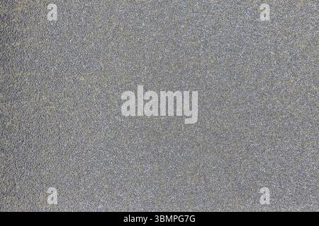Gray asphalt surface with a rough texture and visible aggregate, ideal for design projects, backgrounds, and urban infrastructure visuals Stock Photo
