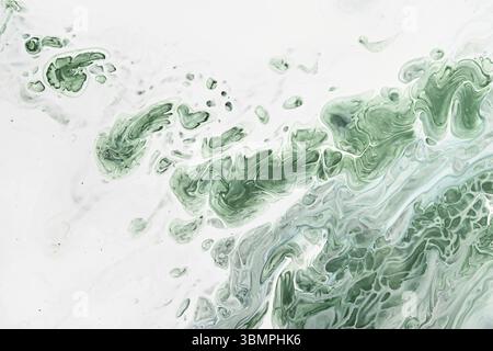 Fluid Art acrylic paints. Abstract mixing green waves on white background. Liquid flows splashes. Marble effect background or texture Stock Photo
