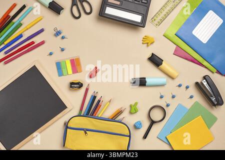 Close-up flat lay photo of a workspace desk with school accessories, such as mini chalkboard, stickers, colored pencils, yellow pencil case, stapler, Stock Photo
