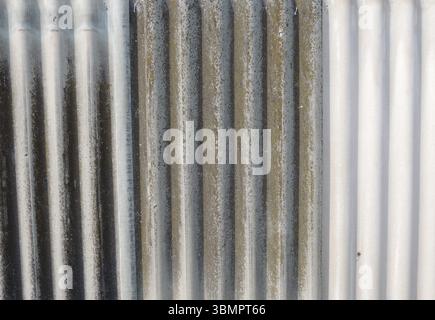 corrugated surface of gray covering material with a gradient of gray color from dark to light shade, corrugated slate in a vertical position Stock Photo