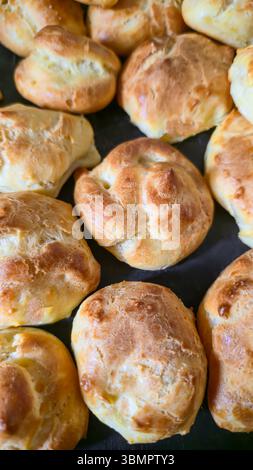 Croquembouche on a light plate covered with caramel. Eclairs with homemade custard cream. Homemade pastries Stock Photo
