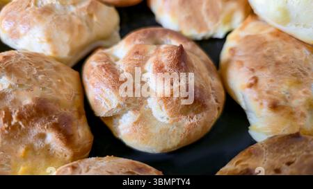 Croquembouche on a light plate covered with caramel. Eclairs with homemade custard cream. Homemade pastries Stock Photo