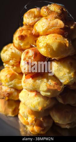Croquembouche on a light plate covered with caramel. Eclairs with homemade custard cream. Homemade pastries Stock Photo
