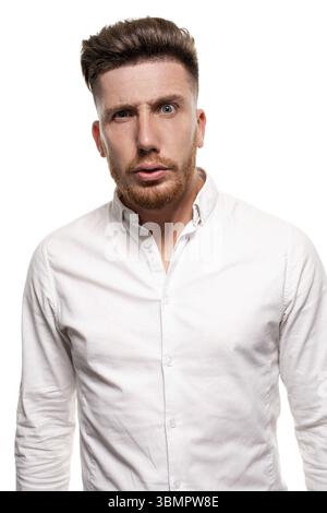 Studio photo of a good-looking man in a white shirt, looking shocked, isolated over a white background Stock Photo