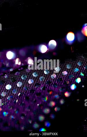 Holographic shiny spots and dots bokeh on fabric for a futuristic disco background Stock Photo