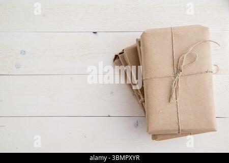 Parcel, gift Packed in eco-friendly paper on light wooden background. the view from the top Stock Photo