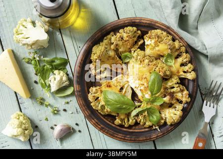 Vegetarian organic food. Baked cauliflower steaks with herbs and spices on a wooden table. Healthy eating, plant based meat substitute concept. View f Stock Photo