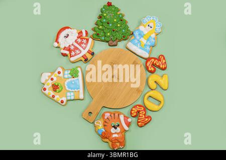 Christmas composition with gingerbread colorful cookies on the green background. Flat lay, copyspace. Merry Christmas, New Year, winter concept Stock Photo
