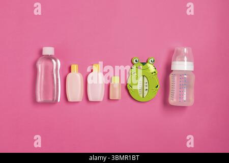 Baby accessories for bath with frog on pink background. Top view. Copy space. Still life. Flat lay Stock Photo