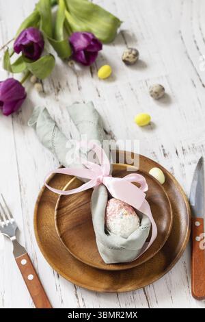 Easter table setting with painted eggs, purple tulip and cutlery on festive table. Table setting for Happy Easter day Stock Photo
