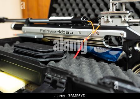 Landkreis Osnabrück, Deutschland 25. Juni 2025: Im Bild: Eine Nahaufnahme zeigt ein Feinpfeilbau Sportgewehr, das auf einem geöffneten, gepolsterten Waffenkoffer liegt. Der Fokus liegt auf der detailreichen Mechanik des Gewehrs, insbesondere auf dem Bereich des Verschlusses. Ein gut sichtbarer roter Faden dient als Ladezustandsanzeiger und signalisiert unmissverständlich, dass sich keine Patrone im Lauf befindet. Diese wichtige Sicherheitsmaßnahme ist typisch für den verantwortungsvollen Umgang im Schießsport. Die Aufschrift Feinwerkbau auf dem Gewehr ist klar erkennbar, was die Qualität des S Stock Photo