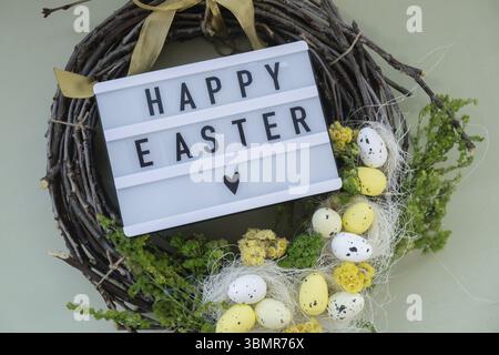 HAPPY EASTER wishes Handmade Easter wreath festive yellow egg decorations. Traditional holiday preparation craft creative decor. Sustainable responsib Stock Photo