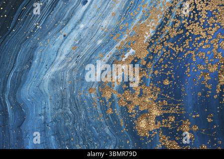 Fluid Art acrylic paints. Abstract mixing blue paint waves. Liquid golden flows splashes. Marble effect background or texture Stock Photo