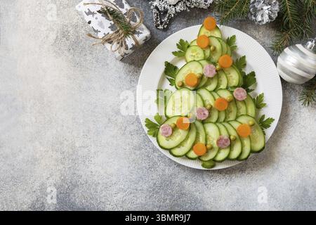 Christmas appetizer. Christmas tree from a salad olivier on a gray stone background. View from above. Copy space Stock Photo