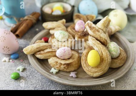 Easter rabbit-shaped buns puff pastry with cinnamon on a stone tabletop. Easter bake idea Stock Photo