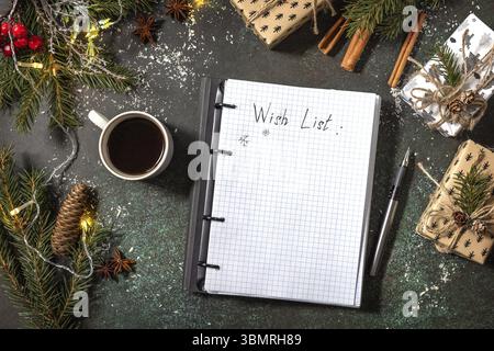 Open planner Notebook with empty wich list and cup of coffee on xmas dark stone tabletop. New year or christmas planning concept. Flat lay Stock Photo