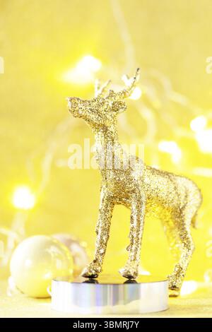 Magic of christmas. Christmas deer gold color palette with decor on a gold background for your greeting card. Copy space Stock Photo