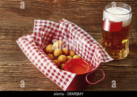 Hot cheese balls with sauce and glass of beer on wooden table. Serving a ready meal in a restaurant, cafe, bar, pub. Still life. Copy space Stock Photo