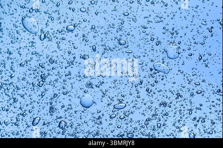 Blue clear gel cosmetic with lots of bubbles texture background . Serum or hair gel texture. Gel skincare product, moisturizing. Stock Photo