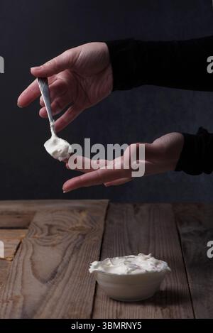 Artistic image showcasing elegant hands gracefully serving mayonnaise, emphasizing texture, motion, and culinary presentation. Stock Photo