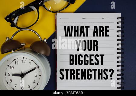 What Are Your Biggest Strengths? text written on notepad with alarm clock on blue background Stock Photo