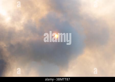 Sun partially hidden behind thick smoke, non-standard situation Stock Photo