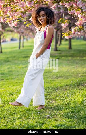A young African American woman with naturally curly hair smiles at the camera. Stock Photo