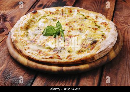 food still-life, Tasty pizza with pesto sauce on wooden background Stock Photo