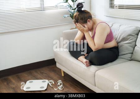 Overweight woman sitting on the sofa stress about loss weight Stock Photo