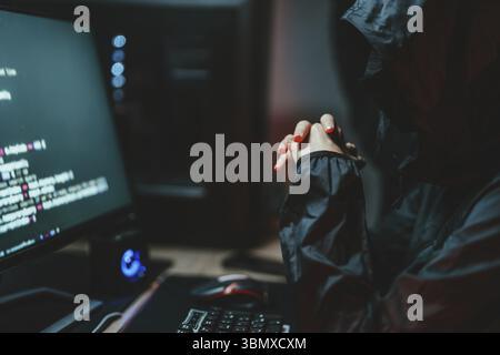 Hooded Hacker coding destroy online data system with virus ransomware in server Stock Photo