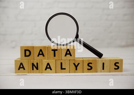 Data Analysis with wooden blocks alphabet letters and magnifying glass on wooden background Stock Photo