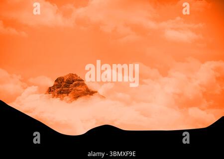 Solitary mountain peak is emerging above thick cloud layer in flat design, with ridge silhouettes Stock Photo