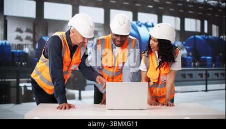 Engineers At The Gas Power Plant Training Workers On Automation. Stock Photo
