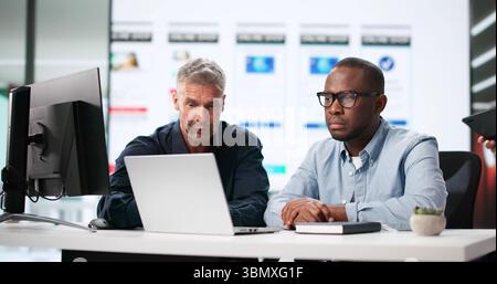 Diverse Team Of UI Designers Creating Mobile App UX Designs. Stock Photo