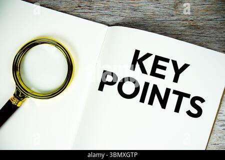 Key Points text message written on paper note with magnifying glass top view on wooden background Stock Photo