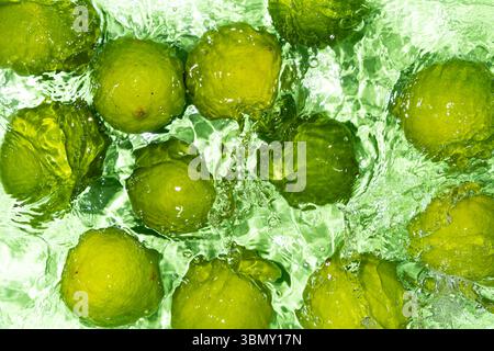Green Limes on Water Surface Flat Lay. Stock Photo