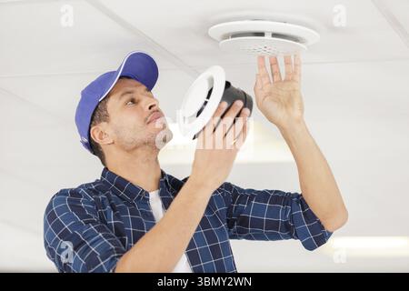 locksmith examines ventilation in the ceiling Stock Photo