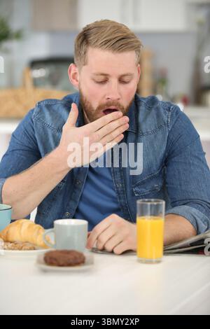 man falling asleep during his breakfast Stock Photo