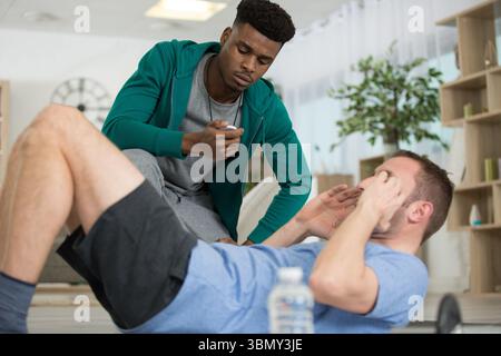 man doing fitness exercise at home with coach Stock Photo
