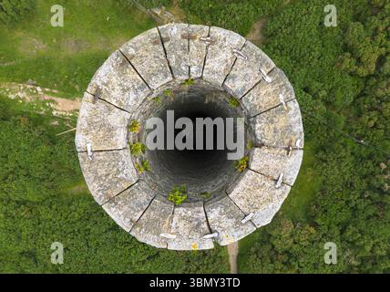 An abstract top-down perspective looking into the circular opening of the historic Ballycorus Lead Mines Chimney, showing its weathered stone Stock Photo