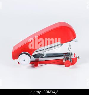 It is Red handheld sewing machine isolated on white. Stock Photo