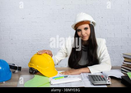 A Female Engineer Actively Engaged in Working on Complex Construction Plans and Designs Stock Photo