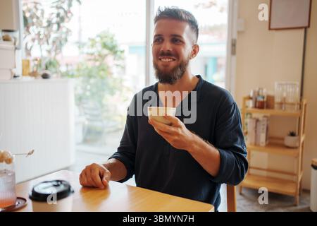 Smiling Man Enjoying Coffee in Cozy Caf Setting Stock Photo