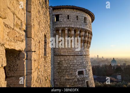 The "Prisoners' tower" and medieval walls of the Castle of Brescia with the city in the background. Lombardy, Italy. Stock Photo