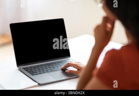 Over shoulder shot of unrecognizable businesswoman working on laptop Stock Photo